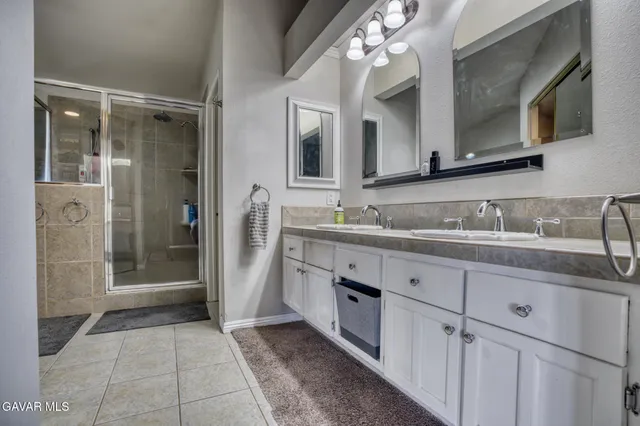 a bathroom with a granite countertop sink a mirror and a shower