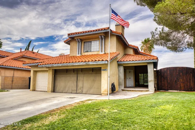 a front view of a house with a garden and garage