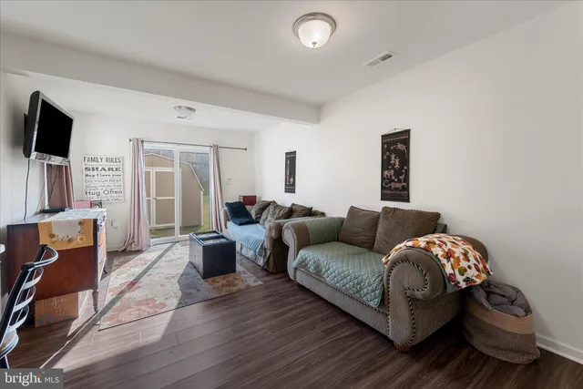 a living room with furniture a flat screen tv and a couch