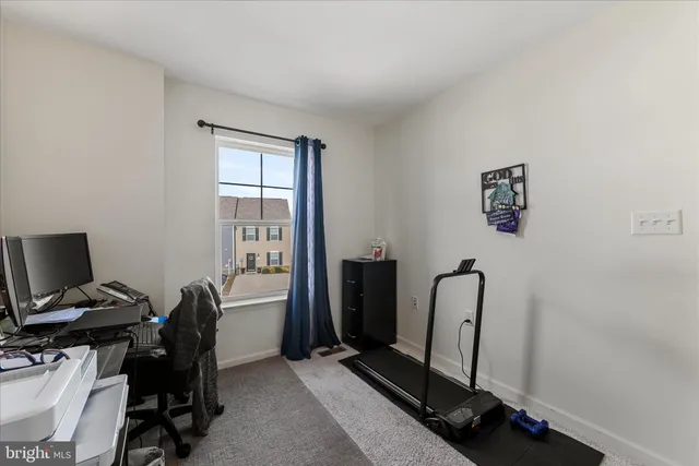 a view of a workspace with furniture and a window