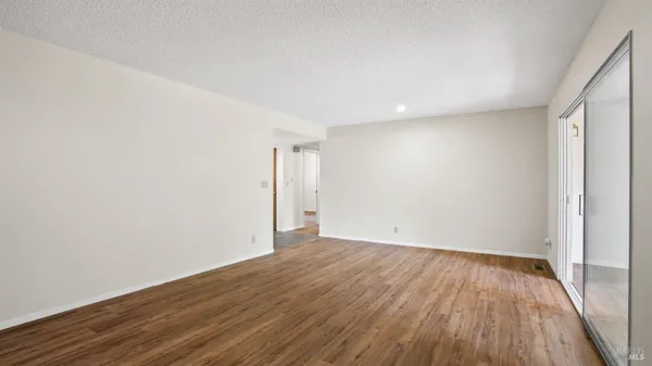 a view of a room with wooden floor and a ceiling fan