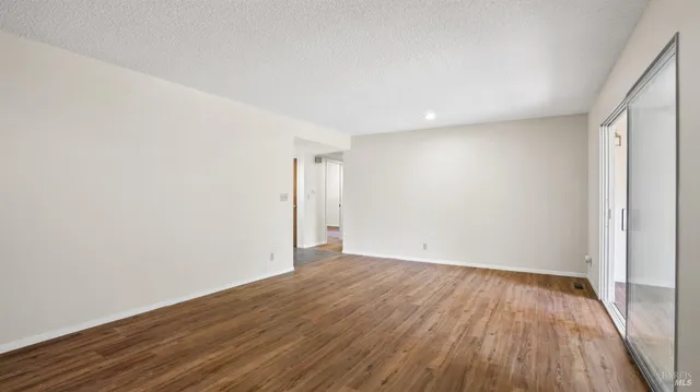 a view of a room with wooden floor and a ceiling fan