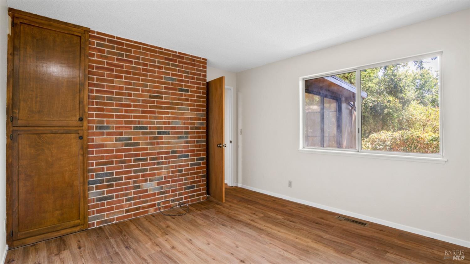 5210-5214 Fulton Road Santa Rosa, CA 95403 - Photo 23 of 60 a view of an empty room with wooden floor and a window
