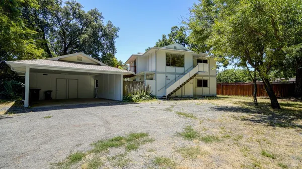 a view of a house with backyard and tree