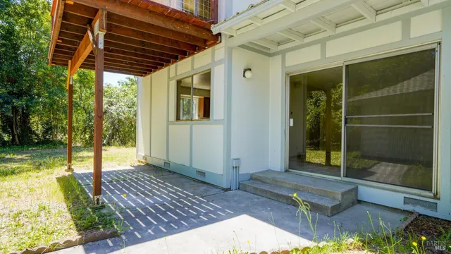 a kitchen with granite countertop white cabinets appliances and a window