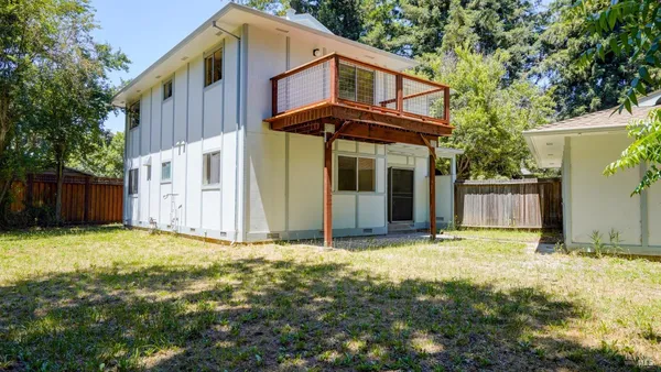 a kitchen with granite countertop white cabinets and white appliances with wooden floor