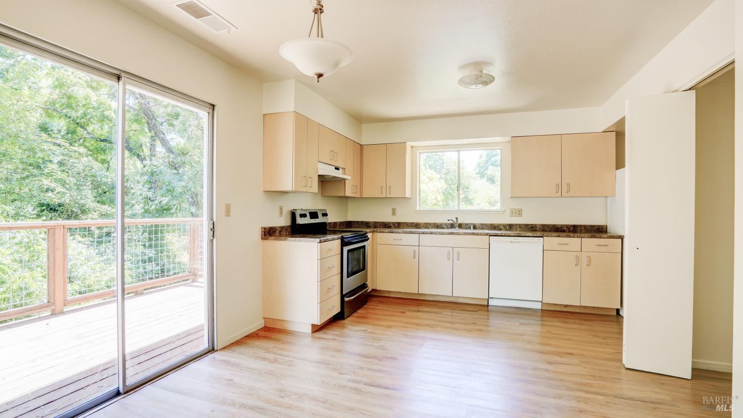 5210-5214 Fulton Road Santa Rosa, CA 95403 - Photo 35 of 60 a kitchen with granite countertop white cabinets and white appliances with wooden floor