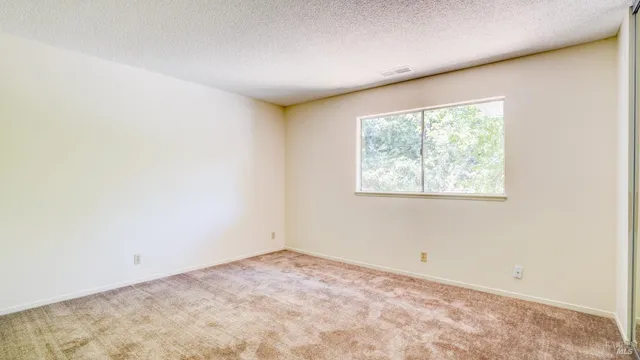 a view of an empty room with a kitchen