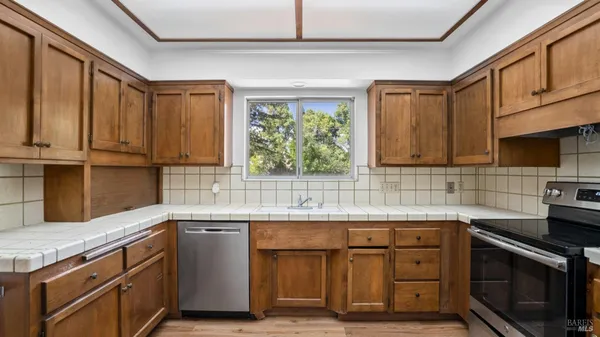 a kitchen with stainless steel appliances a stove sink and cabinets
