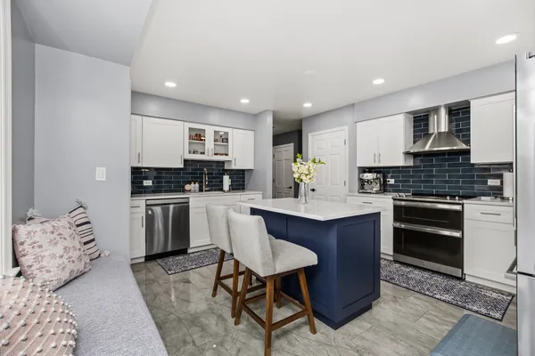 a kitchen with granite countertop a sink cabinets and stainless steel appliances