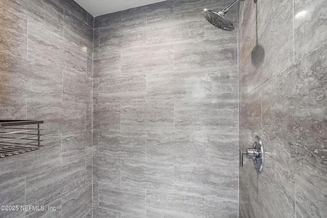 a bathroom with a granite countertop double vanity sink and a mirror