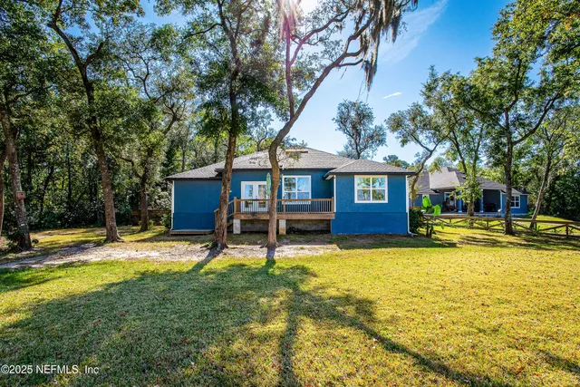 a view of a house with a yard and wooden fence