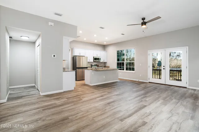 a view of a kitchen with wooden floor and a window