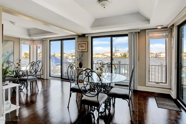 a view of a dining room with furniture large windows and wooden floor