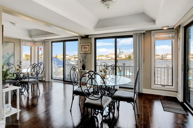 a view of a dining room with furniture large windows and wooden floor