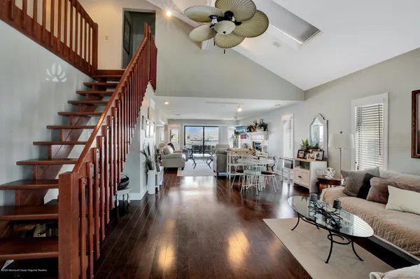 a living room with lots of furniture hardwood floor and a ceiling fan