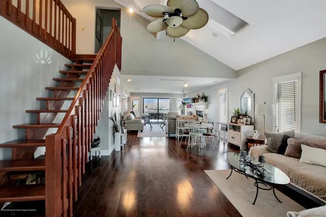 a living room with lots of furniture hardwood floor and a ceiling fan