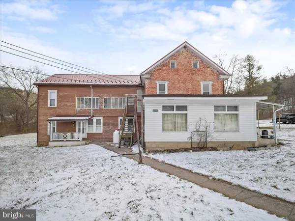 a front view of a house with a yard covered in snow