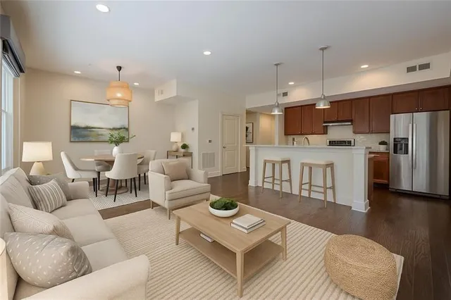 a living room with furniture a refrigerator and kitchen view