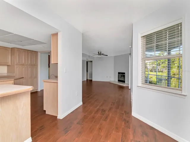 a view of empty room with wooden floor and fan