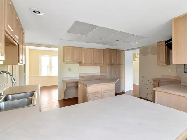 a large white kitchen with a window and stainless steel appliances