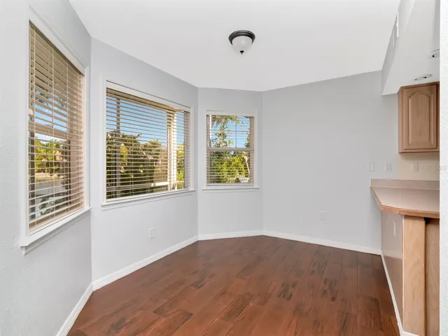 a view of a bedroom with wooden floor and a window