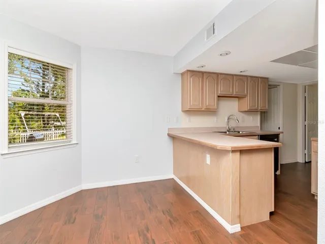 a kitchen with granite countertop a sink cabinets and wooden floor