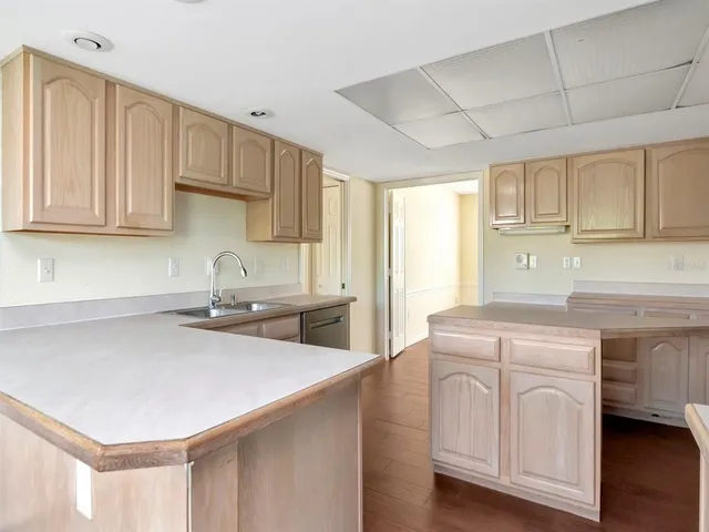 a kitchen with white cabinets and sink