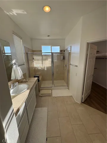a bathroom with a granite countertop sink a toilet a mirror and shower