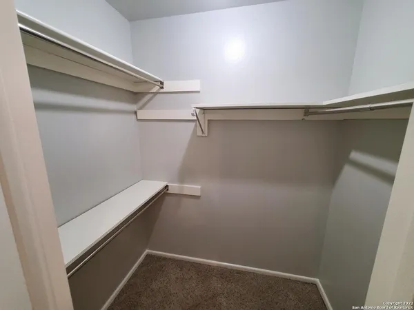 a view of a closet with racks on the wall