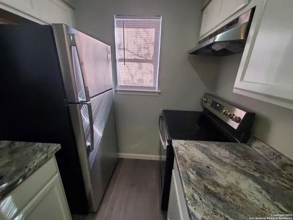 a kitchen with a refrigerator and a stove