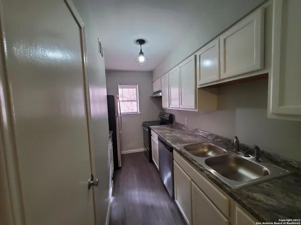 a kitchen that has a sink stainless steel appliances and cabinets