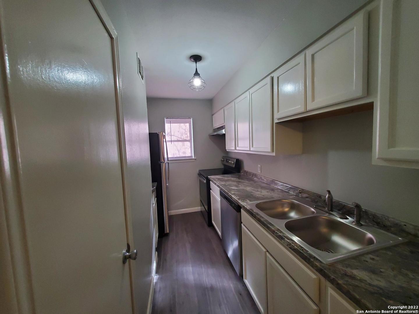 911 Y Vance Jackson Road San Antonio, TX 78201 - Photo 5 of 18 a kitchen that has a sink stainless steel appliances and cabinets