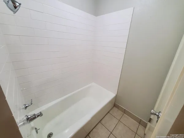 a bathroom with a bathtub a mirror a vanity and vanity