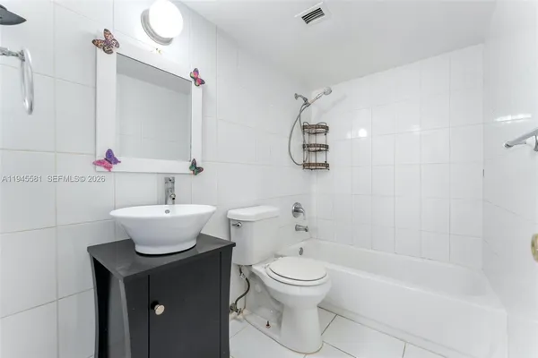 a bathroom with a white sink toilet and shower