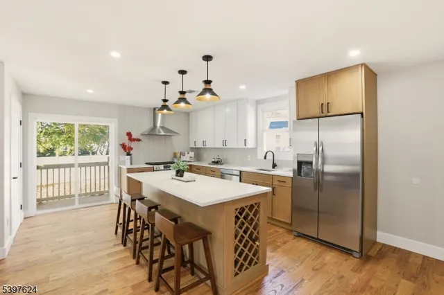 a kitchen with kitchen island a refrigerator a stove a sink and a refrigerator