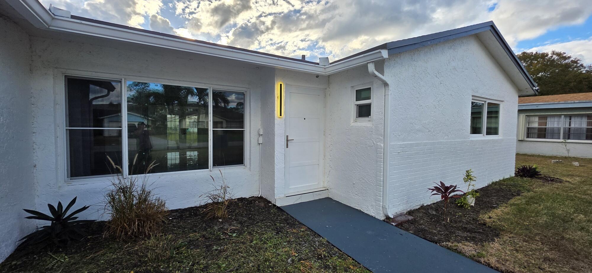 7112 Pine Manor Drive Lake Worth, FL 33467 - Photo 4 of 32 a view of a house with a large window and yard