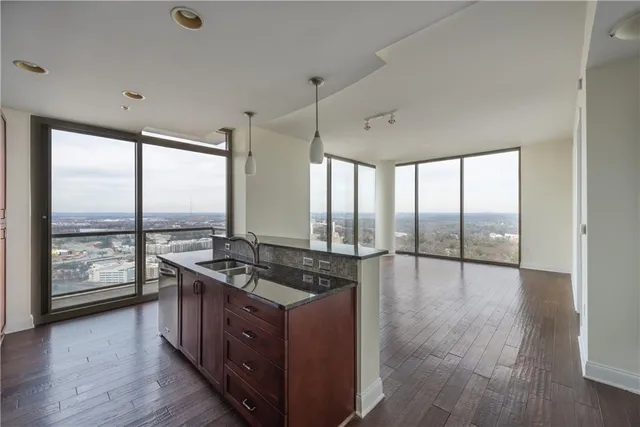a kitchen with stainless steel appliances granite countertop a stove and a wooden floors