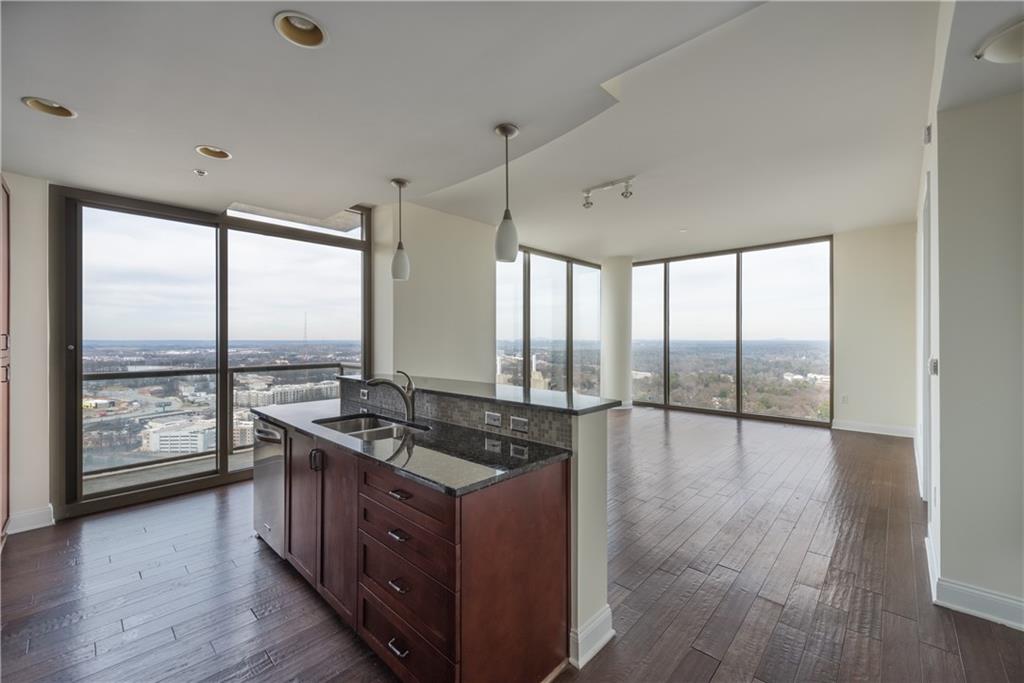 a kitchen with stainless steel appliances granite countertop a stove and a wooden floors