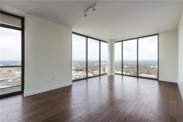 a view of an empty room window and wooden floor