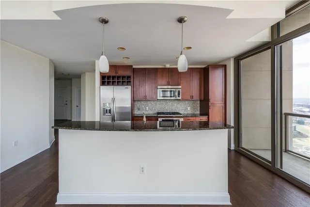 a kitchen with stainless steel appliances granite countertop a sink a stove and a refrigerator
