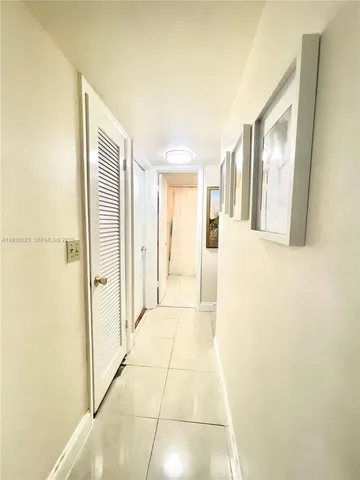 a view of a hallway with wooden floor and a bathroom