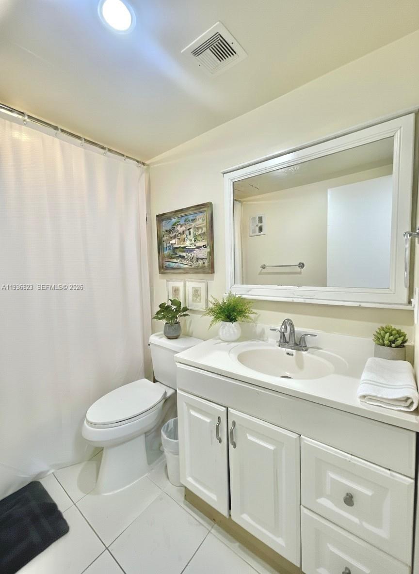 636 Northwest 13th Street, Unit 230 Boca Raton, FL 33486 - Photo 16 of 25 a bathroom with a toilet a sink a mirror a