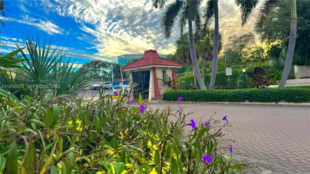 a view of a table and chairs in a yard with potted plants
