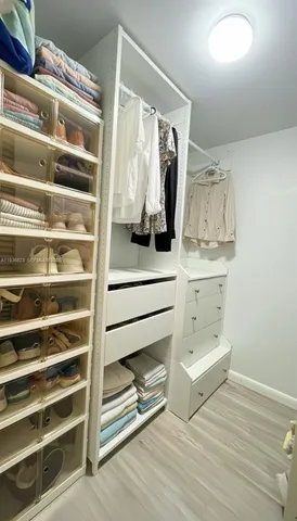 a view of walk in closet with clothes and shoes