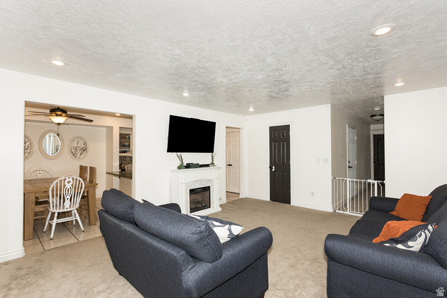 7797 North Windhover Road Eagle Mountain, UT 84005 - Photo 7 of 33 Carpeted living area featuring a built-in fireplace with a white surround and an overhead television mount