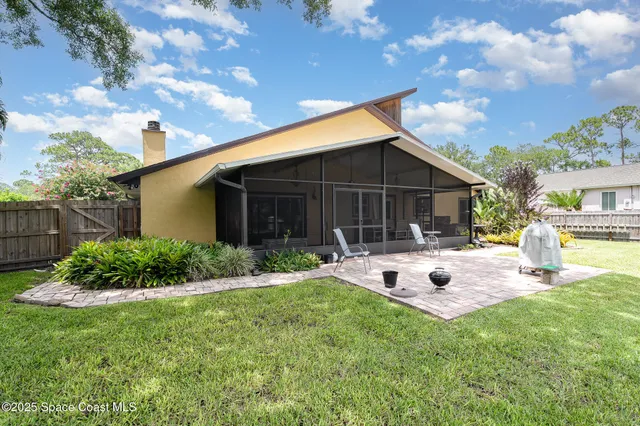 a view of a house with backyard and sitting area