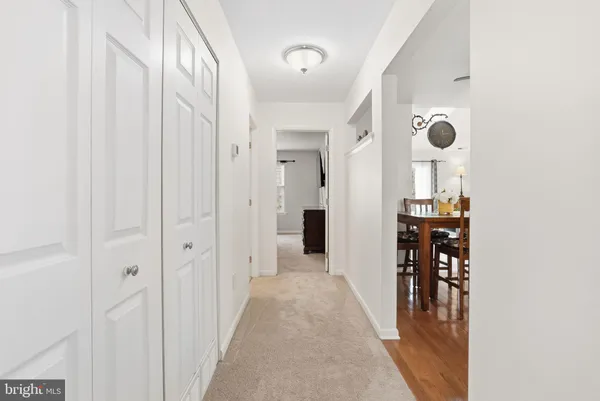 a view of a hallway with closet and a window