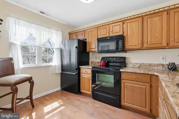 a kitchen with stainless steel appliances granite countertop a refrigerator stove and microwave