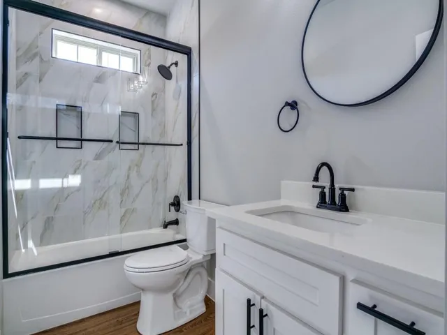 a bathroom with a toilet a sink and mirror